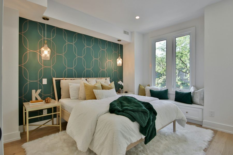 Bedroom with a deep green geometric honeycomb accent wall behind the headboard